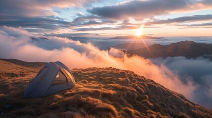 Wall Mural - A small orange tent is set up on a grassy hillside overlooking a cloudy sky