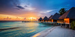 Tropical beach panorama view, Bungalows stay in Sea, coastline with palms, Caribbean sea under sunset light.