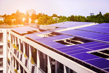 Wall Mural - Solar Panels Roof Apartment Building. Modern High-rise Multifamily Building Apartment Block with Solar Panel Roof System with Sun Light Reflection.