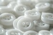 © Fotograf - A pile of white buttons on a table. Perfect for fashion or sewing projects