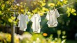White children's clothes hung neatly on an outdoor clothesline.