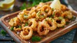 Delicious fried squid served on a rustic wooden cutting board. Perfect for seafood lovers