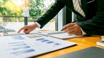 Wall Mural - Young Asian male businessman is pressing a calculator to calculate income, taxes and expenses, credit card bill for payment or payday at home. Close-up pictures