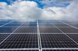 Photovoltaikanlage zur Stromerzeugung auf einem Acker vor wolkigem Himmel