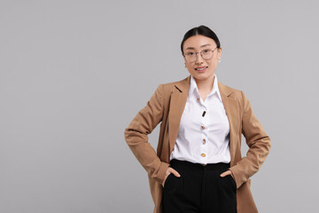 Sticker - Portrait of smiling businesswoman on grey background. Space for text