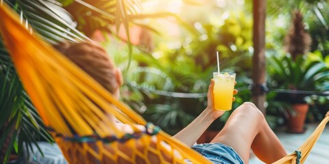 Poster - A woman is relaxing in a hammock with a glass of orange juice