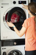 Laundry or clothes dryer machine with woman opening the cover or lit