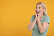 © New Africa - Portrait of happy surprised woman on yellow background, space for text