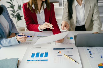 Fototapete - Three women are sitting at a table with papers and pens