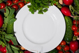 Fototapeta Mapy - plate, background for text with fresh seasonal vegetables, closeup