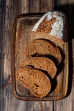 Fototapeta Mapy - sliced rye bread on a wooden cutting board, vertical top view