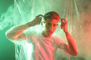 Poster - Stylish young man wearing clear coat and glasses in neon lights