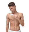 © New Africa - Handsome man applying lotion onto his body on white background