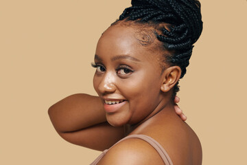 Portrait of cheerful Black woman with braided hair turning back to camera