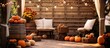 A patio adorned with orange pumpkins, wooden barrels, cozy chairs, and vibrant flowers, creating a charming fallinspired interior design
