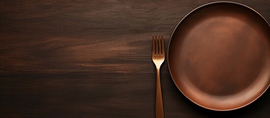 Sticker - An empty plate and fork rest on a hardwood table, ready for a delicious dish to be served. The tableware and cutlery gleam against the warm wood, awaiting the next culinary creation