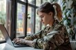 Female Soldier in Military Uniform Typing on Laptop