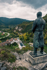 View from the top of the hill with hero statue on Orthodox Monastery in a valley