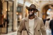 © Татьяна Евдокимова - Confident young man with shopping bags enjoying a day out in a posh shopping arcade