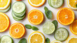 Assorted oranges and cucumbers sliced up, arranged on a white background