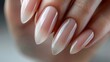 Elegant almond-shaped nails with a nude ombre finish. Studio shot for nail beauty and fashion design inspiration