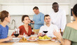 © JackF - Merry male and female friends having lunch with wine and talking warmly in comfort of their house
