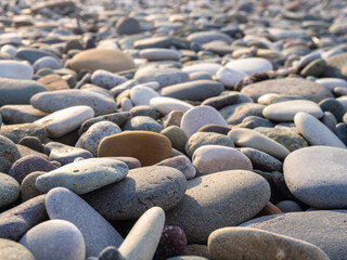 Gray sand and stones on the beach. Stone in the foreground.