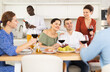 © JackF - Multiethnic women and men friends talking and drinking wine in the kitchen