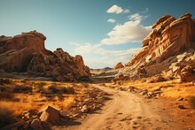 Dirt Road Through Desert Valley, Surrounded By Rocks Under Blue Sky