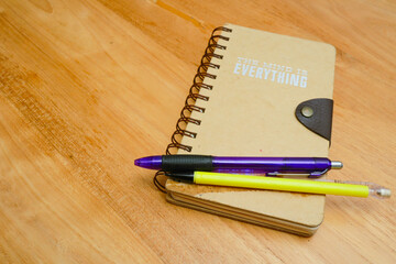 notebook and pen over wooden background