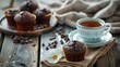Chocolate muffins with fragrant tea. On a wooden background.