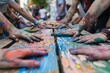 A gathering of individuals displaying their hands covered in colorful paint during a community event or urban activation project