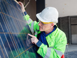 Fototapeta  - Professional electrical engineers in a safety helmet and uniform checking photovoltaic solar panels for maintenance, professional engineer concept about solar cell system.