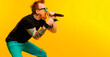 © pintxoman - Rocker man in profile holding a microphone singing a song. Karaoke concept, music lovers