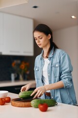 Wall Mural - Kitchen Magic: A Beautiful Young Woman, Cooking a Healthy Vegetarian Salad, Standing in Her Home's Beautifully Lit Interior.