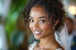 © Jelena - Radiant young woman with a bright smile and curly hair attending a social event