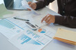 © ijeab - Accountants are using calculators to calculate income, expenses, and investments.