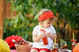 Fototapeta Dmuchawce - Lemonade Stand. Adorable little girl trying to sell lemonade. strawberry lemonade with ice and mint as summer refreshing drink in jars. Cold soft drinks with fruit. Child drinking lemonade in jar