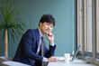 © 茂輝 田代 - グリーンのオフィスとスーツとPCの男性