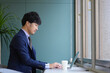 © 茂輝 田代 - グリーンのオフィスとスーツとPCの男性