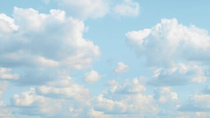 blue sky covered with slowly moving white clouds. a bright landscape with cumulus clouds floating fr