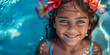 Young smiling girl with exotic flowers crown in blue water. Banner with copyspace. Shallow depth of field.