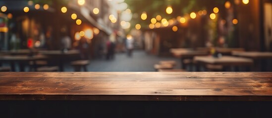 Canvas Print - An empty wooden table stands in a restaurant, with a blurry background of the city streets outside. The buildings asphalt road and automotive lighting can be seen through the window