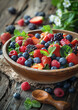 Tazón de madera lleno de frutos rojos y bajas sobre mesa de madera. Comida para vegano de frutos rojos, frambuesa, y arándanos