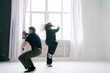 © Mihail - Energetic Duo Performing a Contemporary Dance Routine in a Bright White Studio