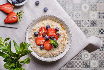 Wall Mural - oatmeal porridge with strawberries blueberries and honey