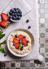 Wall Mural - oatmeal porridge with strawberries blueberries and honey