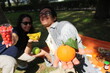 two friends out on a picnic in the garden holding healthy fresh fruits *2
