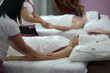 Two masseuses doing hand massage for woman and man in spa salon