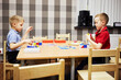 © Pavel Losevsky - Two little boys solve puzzles sitting at desk in classroom at children club.